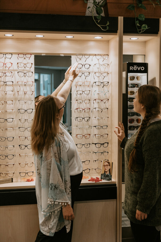 An optician helps a patient choose frames